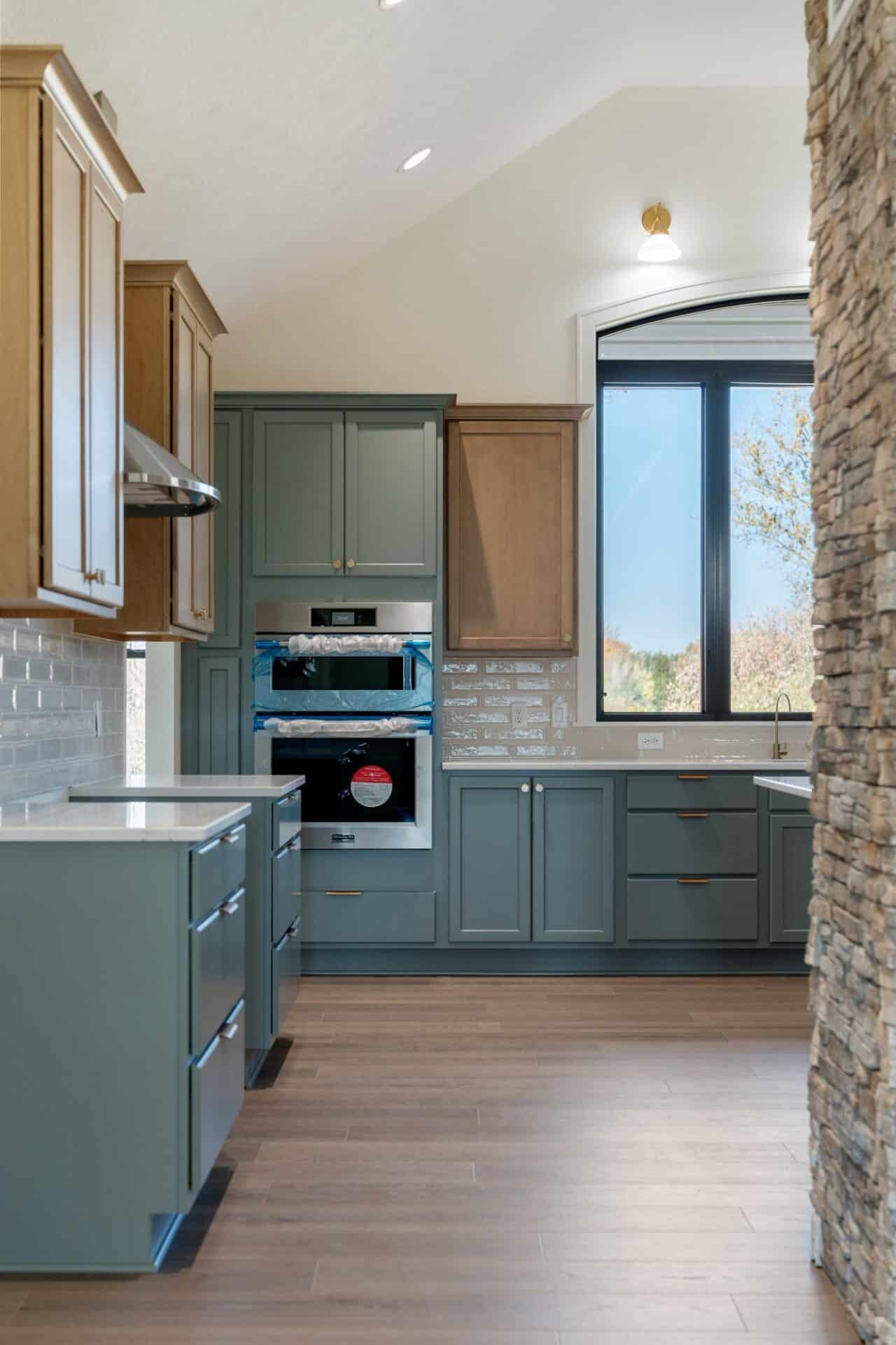 sage-green-cabinets-stone-accent-wall-plain-township-homes